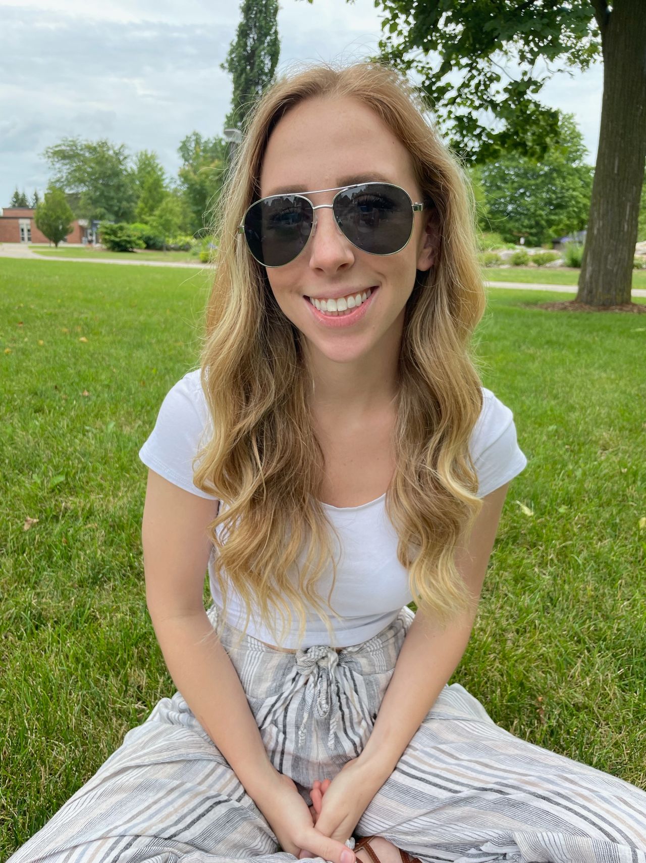 Woman sitting on the grass with nice pair of StaysOn Eyewear