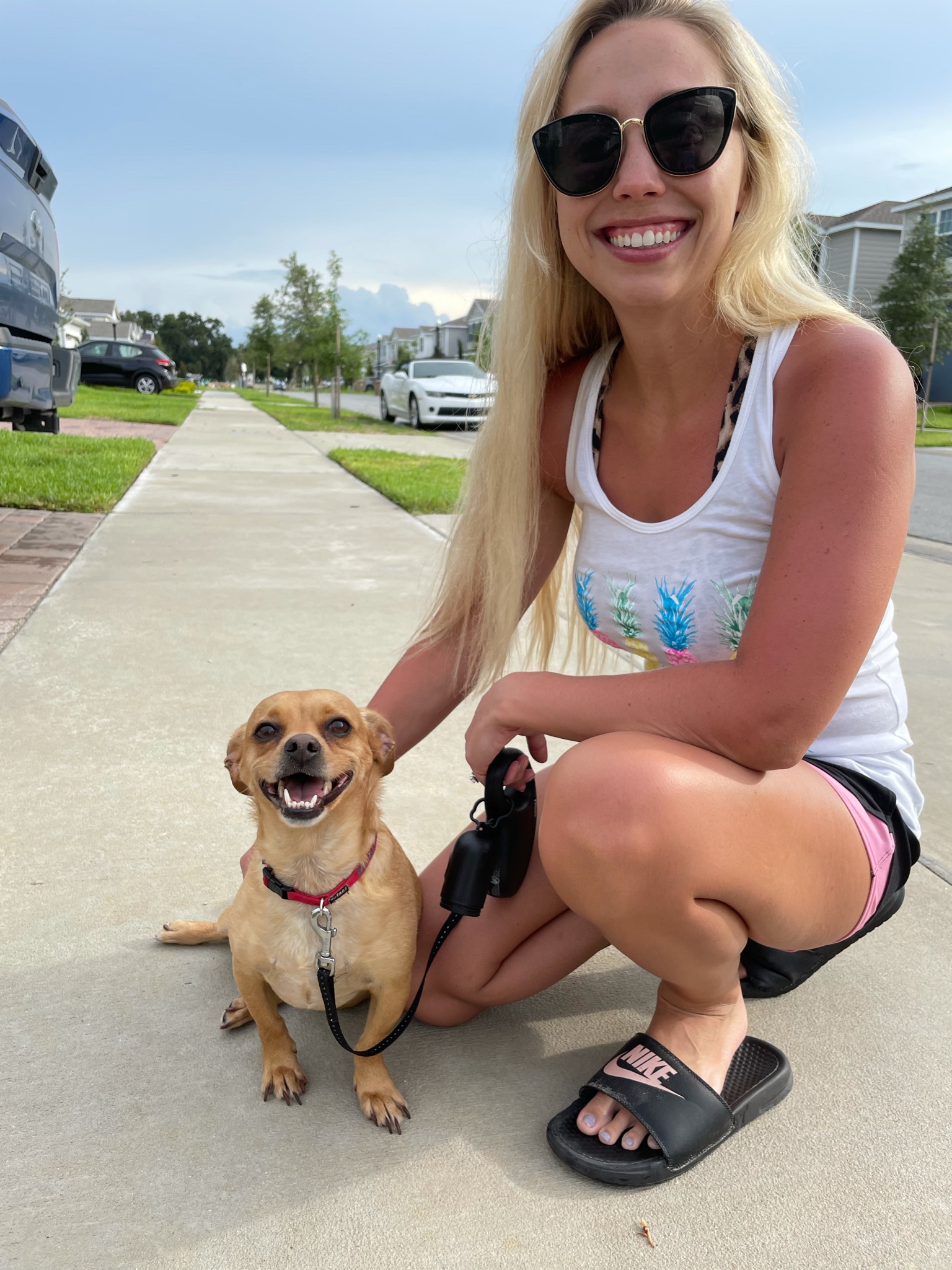 Smiling woman with shades and dog on a leash